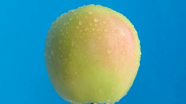 苹果有水滴在明亮的蓝色背景上 多汁和有用水果的主题拍摄 — 图库视频影像