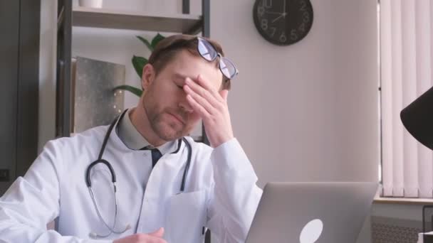 Przygnębiony Młody Lekarz Bólem Głowy Siedzący Biurze Przepracowany Lekarz Swoim — Wideo stockowe