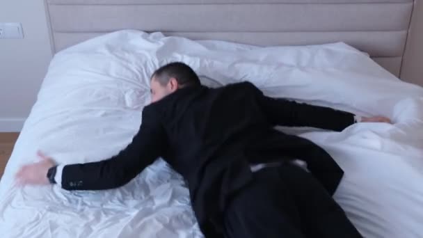 Уставший Молодой Человек Деловом Костюме Падает Белую Кровать Отдых После — стоковое видео