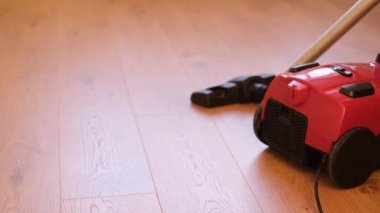 Parlak ahşap zemini elektrikli süpürgeyle temizleme işlemi. Ev, ev temizliği.