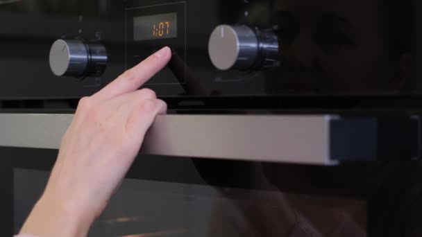 一个女人的手打开了一个黑色的电炉 现代厨房用具 — 图库视频影像