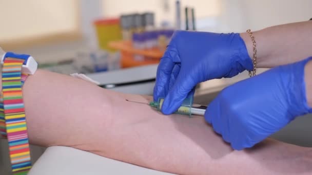 血液採取のための注射器を患者に注射する女性医師のクローズアップ 看護師が患者の血液サンプルを採取して — ストック動画
