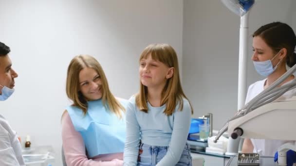 小児の歯科治療 歯医者の診察で娘さんと一緒にいる母親 子供の世話 — ストック動画