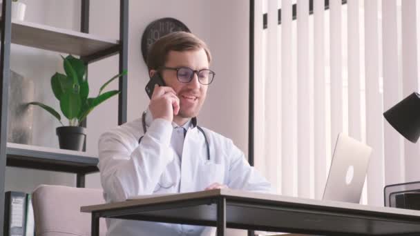 Młody Lekarz Rozmawia Przez Telefon Biurze Szczęśliwy Lekarz Rozmawia Pacjentem — Wideo stockowe