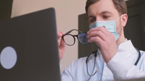 Médico Trabalha Computador Limpa Óculos Olha Para Monitor Consultas Médicas — Vídeo de Stock