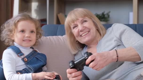祖母和孙女用游戏机玩电子游戏 快乐的家人在家里沙发上放松 — 图库视频影像
