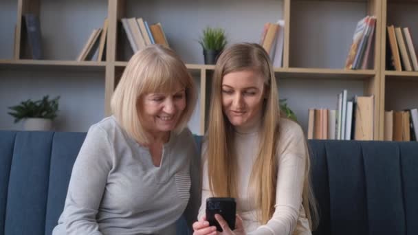 Een Mooie Blonde Met Haar Moeder Kijkt Naar Een Smartphone — Stockvideo