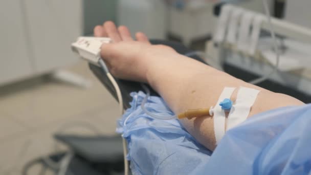 腕のパルス酸素濃度計とカテーテルを備えた病院で麻酔下の患者の閉鎖 人々を治療するという概念 — ストック動画