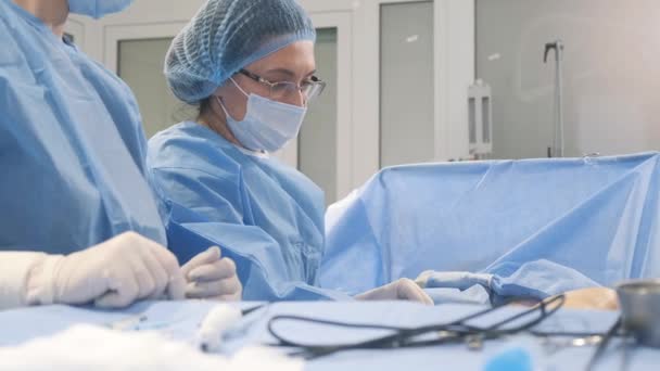 臨床医の外科医とアシスタントは 近代的で革新的なレーザーアブレーション法を使用して 静脈瘤の足で手術を行います 4Kビデオ — ストック動画
