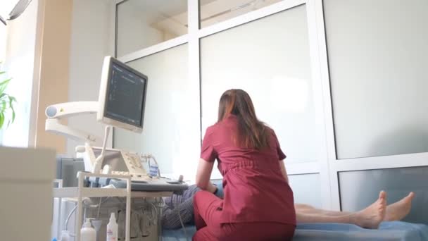Femeie Medic Efectuează Ecografie Picioarelor Pacienților Într Clinică Modernă Varice — Videoclip de stoc