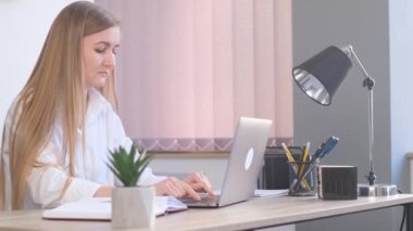 Güzel bir iş kadını bilgisayarın önünde masasında oturuyor, yorgun ve uyumak istiyor. Ofiste çalışmaktan yoruldum. 4k video