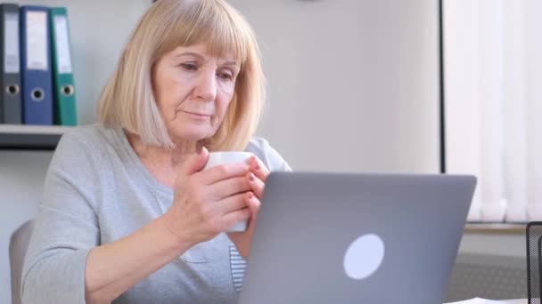 Abuela Comunica Través Enlace Vídeo Sosteniendo Una Taza Sus Manos — Vídeos de Stock