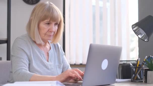 年长的女人在上班时间面带微笑 她精力充沛 心情很好 和年纪较大的计算机一起工作 4K视频 — 图库视频影像