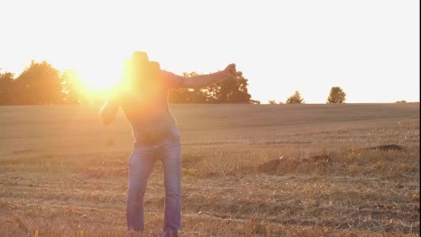 満足のいく農家が畑で面白い踊りを披露する 現場でのシルエットの日没または日の出 — ストック動画