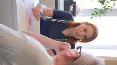 Yaşlı bir hastayla konuşan kadın bir doktorun dikey videosu. Yaşlılıkta kardiyovasküler hastalıkların önlenmesi
