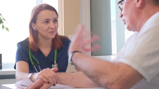 笑顔の女性医師は彼女の手を握って患者を慰める 診療所の医師のケアと思いやり 4Kビデオ — ストック動画