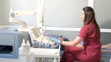 Bir doktor, klinikte yaşlı bir hastanın bacak eklemlerinin ultrasonunu yapar. Yüksek kalite 4k video