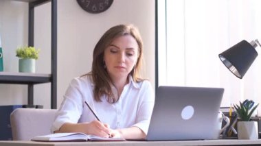 Genç Avrupalı kadın yönetici iş kadını masada oturuyor ve dizüstü bilgisayar üzerinde çalışıyor. Modern ofis şirketi. İş teknolojisi kavramı.