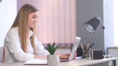 Resmi takım elbiseli kadın yönetici iş kadını şirket ofisindeki dizüstü bilgisayarında yazı yazıyor. Dizüstü bilgisayarda çalışan iş kadını