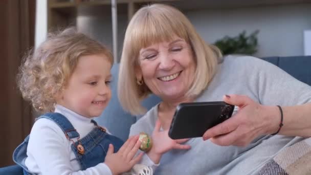 Mutlu Bir Büyükanne Torunuyla Evde Vakit Geçirir Akıllı Telefondan Çizgi — Stok video