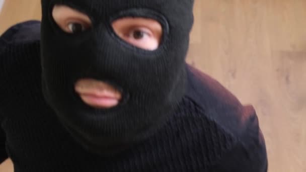 一个戴着黑色面具的强盗的脸出现在监控摄像头上4 罪犯用手关上了摄像头 — 图库视频影像