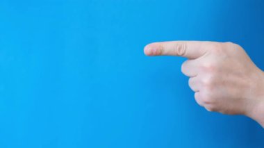 Mans mavi arka planda el hareketi. İşaret parmağı mavi arkaplandaki bir şeyi gösteren bir erkek eli. Mavi ekranda Chromakey