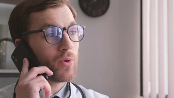 Jonge Knappe Dokter Aan Telefoon Zijn Kantoor Medische Consulten Door — Stockvideo
