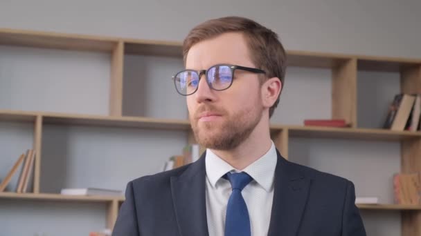 眼鏡をかけたサラリーマンの肖像画 彼はカメラを見て笑っている 事務所のマネージャーの仕事 実業家 — ストック動画