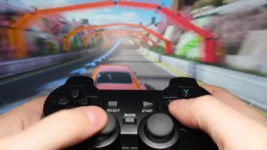 Genç bir adam makinelerde bilgisayar oyunu oynuyor, oynamak için joystick kullanıyor. Boş zaman. Bilgisayar oynatıcı