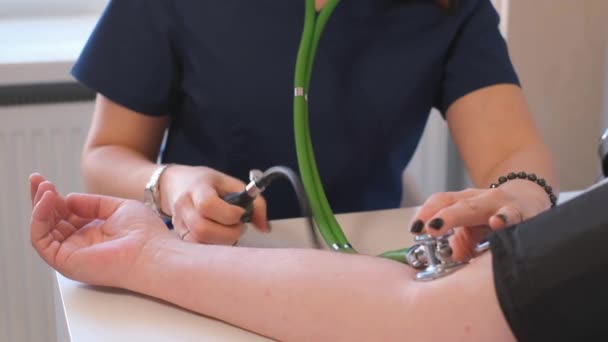 女性医師は高齢者の血圧を測定し 診断を行います 心臓専門医が事務所で働いてる — ストック動画