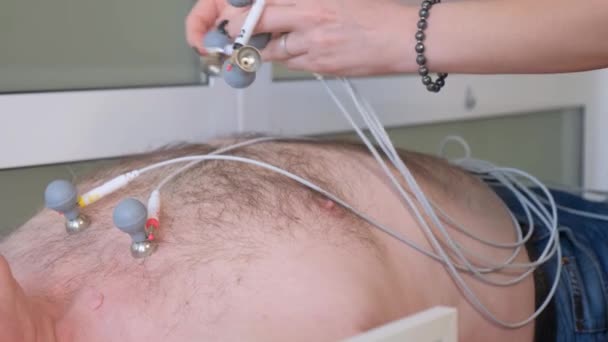 Μια Γυναίκα Καρδιολόγος Τοποθετεί Λαστιχένιους Ηλεκτρονικούς Αισθητήρες Κενού Για Ηκγ — Αρχείο Βίντεο
