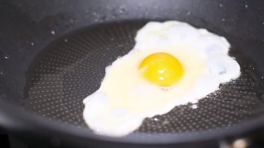 Yumurta ısıtılmış yağda tavada kızarır. Sağlıklı kahvaltı.