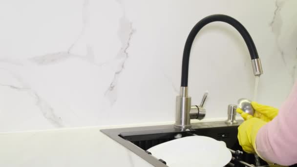 戴手套的女人洗碗 把勺子放在现代的白色厨房里 清洁概念 — 图库视频影像