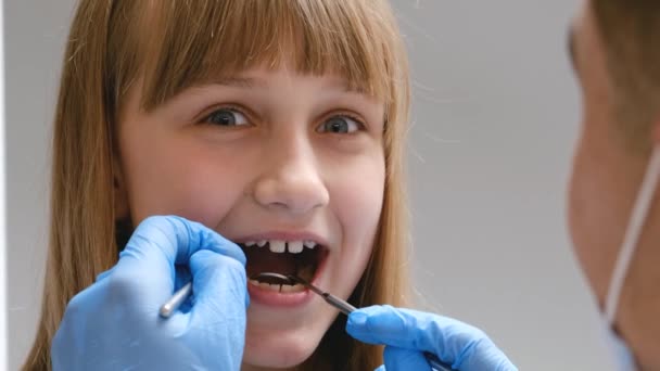 Γιατρός Εξετάζει Δόντια Των Παιδιών Ένας Παιδοοδοντίατρος Εξετάζει Δόντια Ενός — Αρχείο Βίντεο