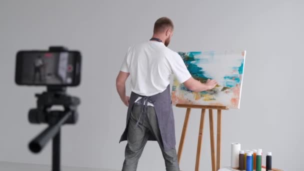 작업복을 미술가는 비디오 블로그에 붓으로 그림을 그리면서 비디오 블로그를 기록합니다 — 비디오