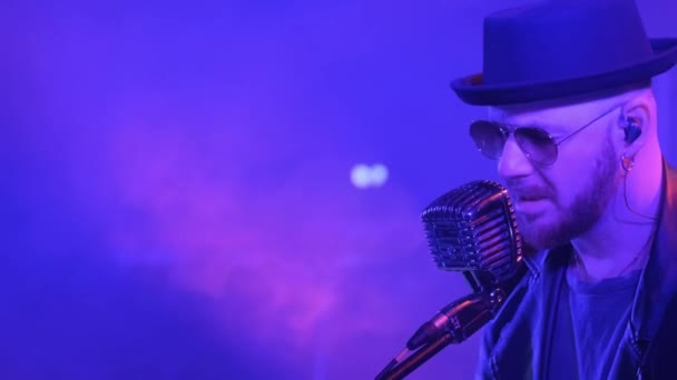スタイリッシュなジャズミュージシャンが大きなステージでマイクに向かって歌っている 彼はサングラスと帽子をかけています ウクライナ テルノピル 2023年3月20日 — ストック動画