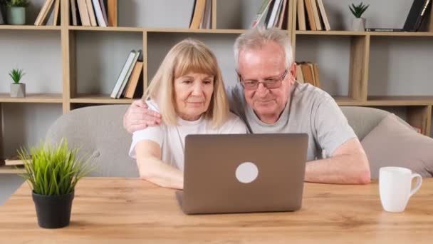 Szczęśliwa Para Seniorów Laptopem Salonie Dziadek Babcia Zakochani Szukają Czegoś — Wideo stockowe