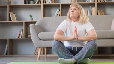 Yaşlı, sarışın bir kadın yoga yapıyor. Kendinle uyum içinde. Kendine zaman ayır.