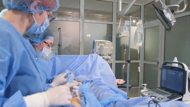 手术室里的操作程序 一个医生和一个护士在手术过程中 看着监视器 操作过程中的技术手段 — 图库视频影像