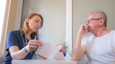 Bir kardiyolog klinikte yaşlı bir adama danışıyor. Kalp hastalıkları. 4k video