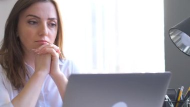 Yorgun bayan ofis müdürü bilgisayarın önünde masasında oturuyor. Ofis işleri yüzünden başım ağrıyor. 4k video