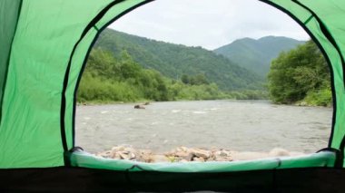 Öfkeli bir dağ nehrinin kıyısındaki çadırdan güzel bir manzara. Ukrayna Karpatlarının güzelliği