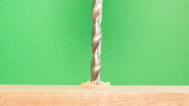 Genişletilmiş metal matkapla tahta yüzeylerde delik açılır. Fiberboard yüzeyi. İş için malzeme ve araç seçimi kavramı