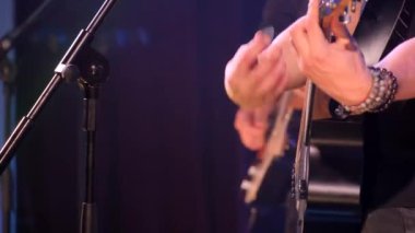 Büyük bir sahnede rock konserinde çalan hızlı akustik gitarın yakın çekimi. Ağır rock müziği. 4k video