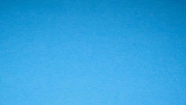 スローモーションで青の背景に落ちる塩焼きピスタチオの山 おいしい明るい黄色のピスタチオ ベジタリアンフード — ストック動画