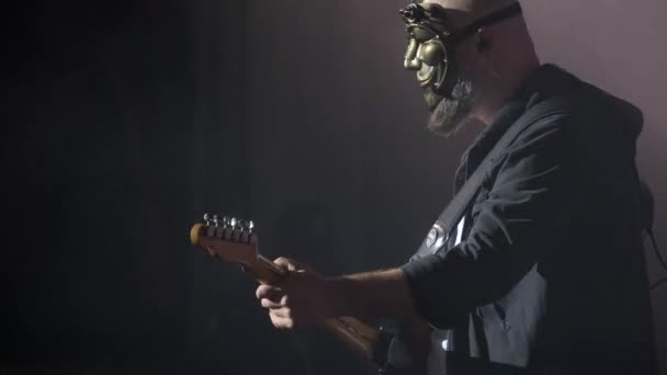 一个戴面具的男人在俱乐部的摇滚音乐会上弹电贝司吉他 大城市的夜生活 红光和蓝光 — 图库视频影像