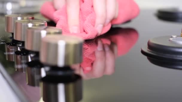 女性の手は 乾いた布で調理するための素敵な金属ガスストーブを拭く モダンなキッチン — ストック動画