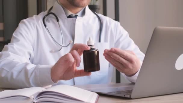 オフィスの職場でオンラインで患者と話す薬と瓶を示すセラピスト 患者と医師のオンライン相談 — ストック動画