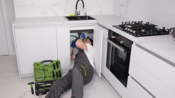 Plumber Lying Floor Repairing Sink Kitchen Male Plumber Fixes Kitchen — Stock Video