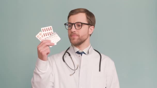 戴眼镜的时髦医生拿出药丸 但不推荐 一个医生在工作室背景上的肖像 4K视频 — 图库视频影像